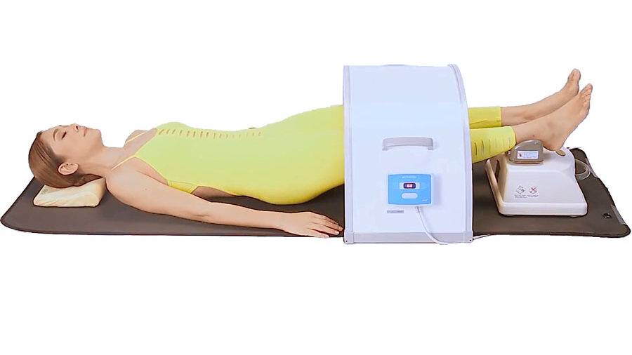 Woman laying on her back on pad using the Infrared dome with the Chi Machine